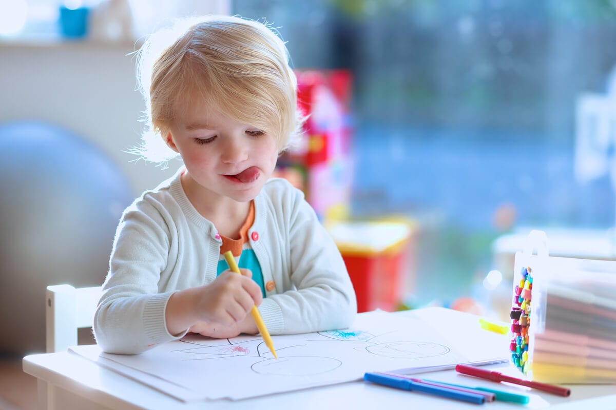 Photo of child, that drawing and learning spanish